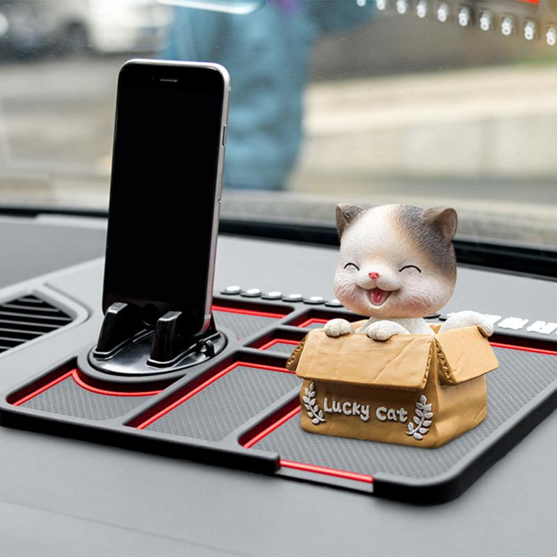Auto-Dekoration Lucky Cat Figur in Box auf rutschfester Armaturenbrett-Matte neben Handyhalterung