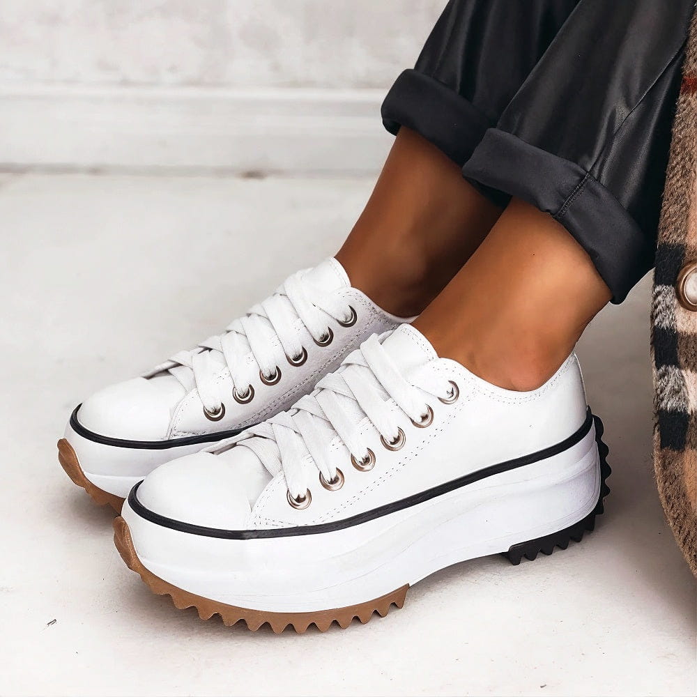 Beige Sneaker mit dicker weißer Plateau-Sohle, schwarzer Stern-Applikation an der Ferse und braunen Details – modische Damen-Freizeitschuhe