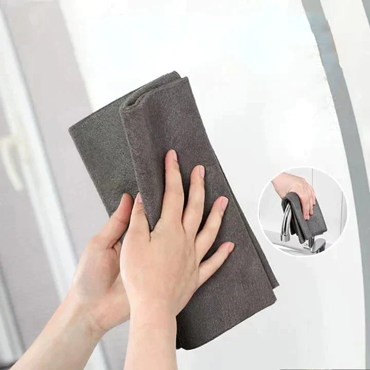 Hand wischt Glas mit grauem Mikrofasertuch für streifenfreie Fensterreinigung