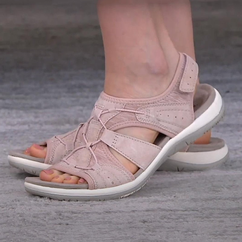 Bequeme blaue Sportsandalen für Damen mit weißen Sohlen, getragen zu weißen Hosen