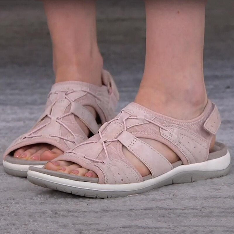 Bequeme blaue Sportsandalen für Damen mit weißen Sohlen, getragen zu weißen Hosen