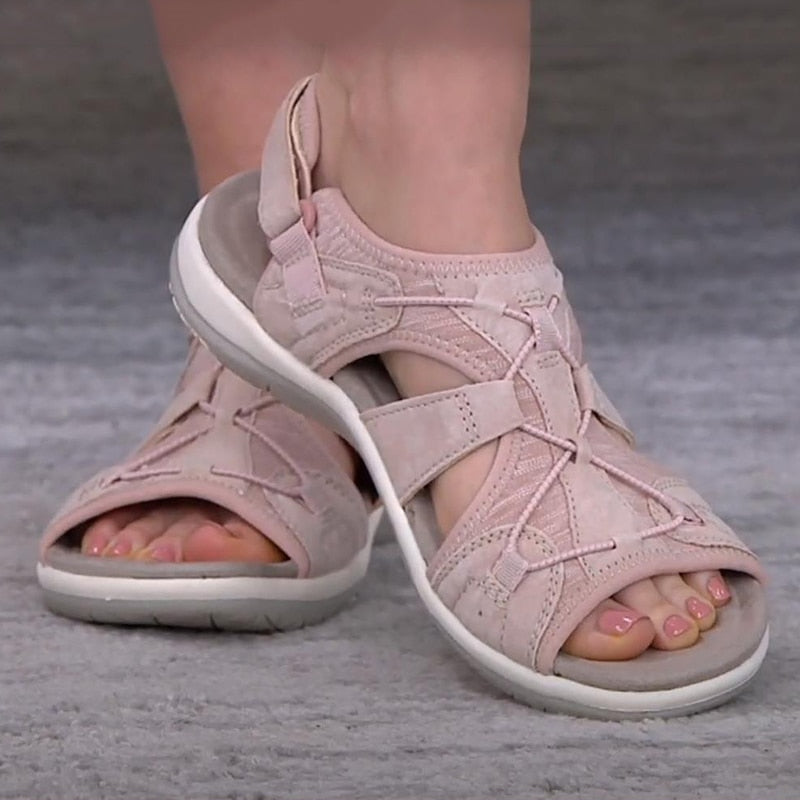 Bequeme blaue Sportsandalen für Damen mit weißen Sohlen, getragen zu weißen Hosen