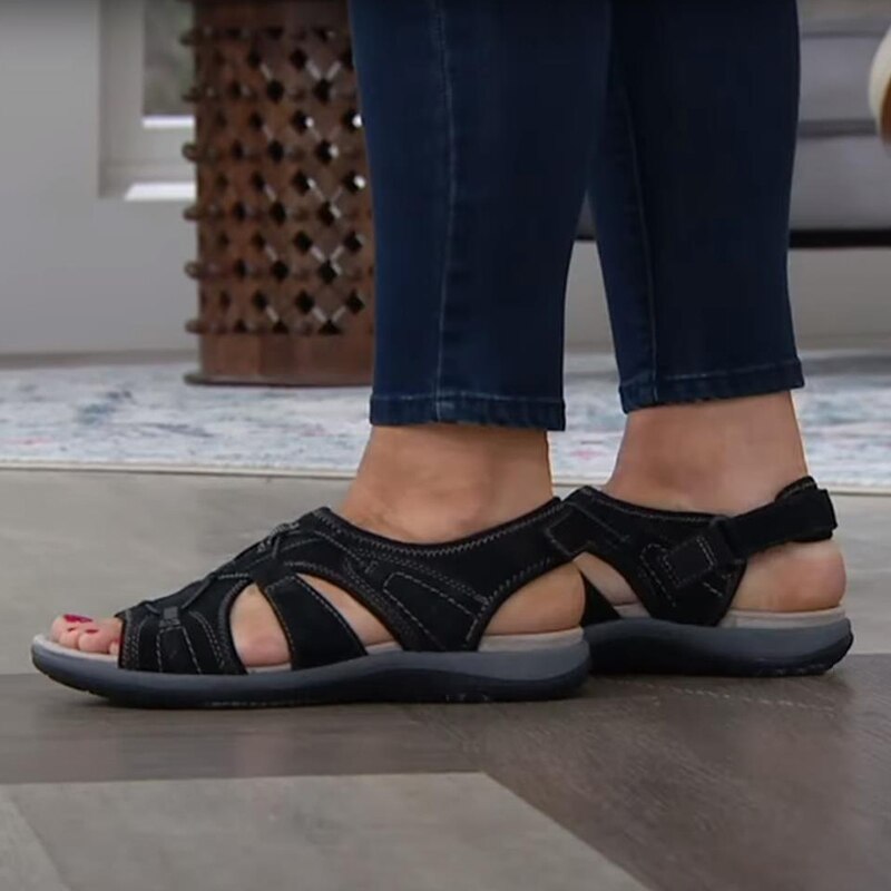 Bequeme blaue Sportsandalen für Damen mit weißen Sohlen, getragen zu weißen Hosen