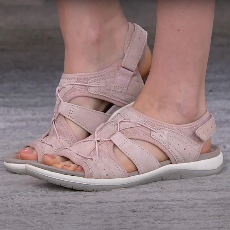 Bequeme blaue Sportsandalen für Damen mit weißen Sohlen, getragen zu weißen Hosen