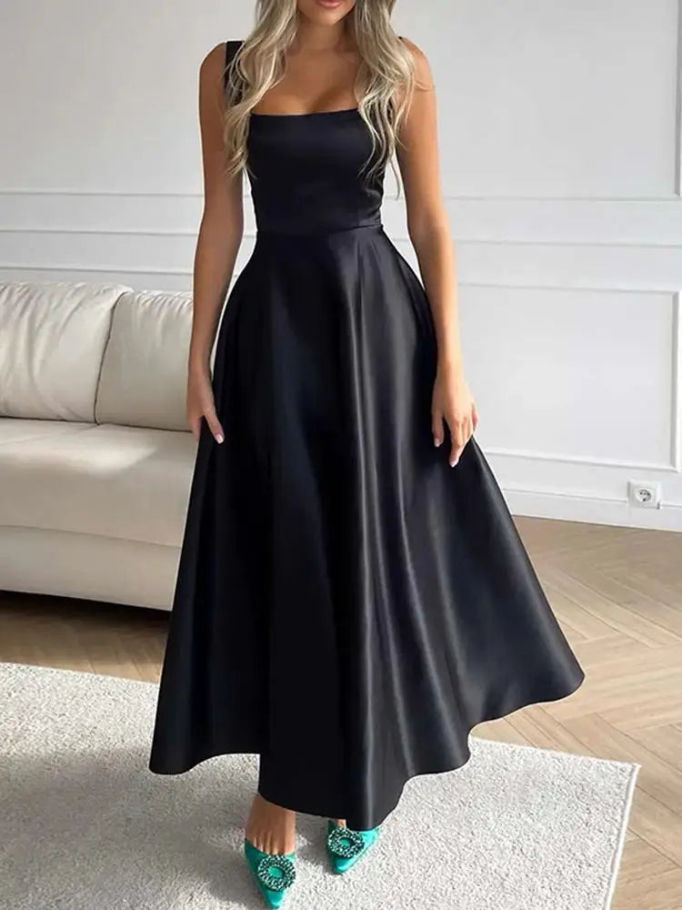 Elegantes schwarzes Abendkleid mit weitem Rock und grünen High Heels im modernen Wohnzimmer