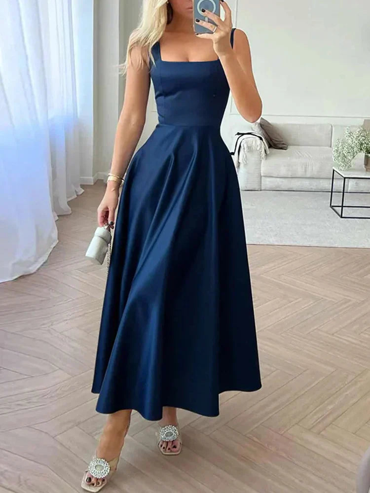 Elegantes schwarzes Abendkleid mit weitem Rock und grünen High Heels im modernen Wohnzimmer