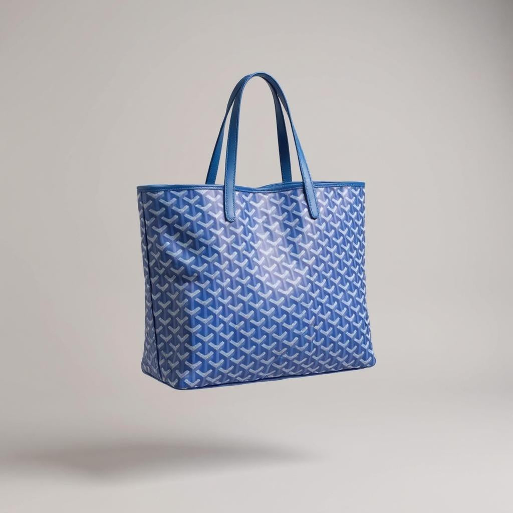 Blaue Tote Bag mit weißen geometrischen Mustern und langen Henkeln, vor hellem Hintergrund schwebend dargestellt.