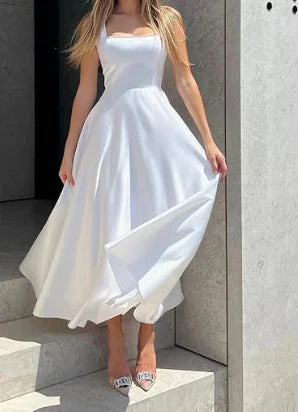 Elegantes schwarzes Abendkleid mit weitem Rock und grünen High Heels im modernen Wohnzimmer
