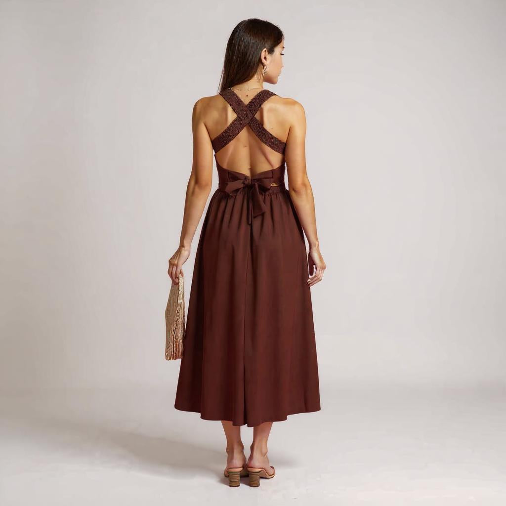 Frau trägt elegantes rotes Midikleid mit Smok-Oberteil, breiten Trägern und A-Linien-Rock, kombiniert mit beigen Sandaletten – Sommerkleid für Damen
