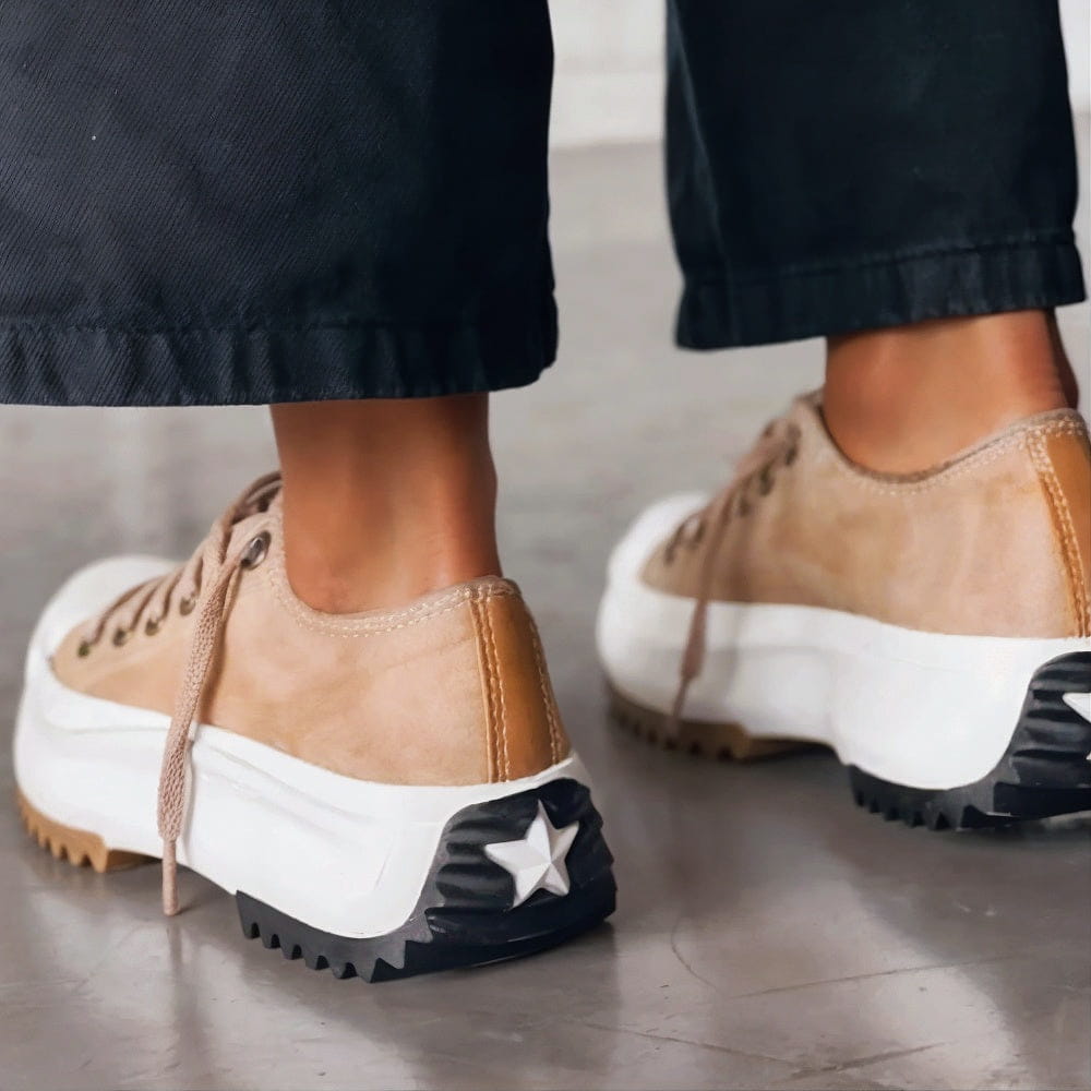 Beige Sneaker mit dicker weißer Plateau-Sohle, schwarzer Stern-Applikation an der Ferse und braunen Details – modische Damen-Freizeitschuhe