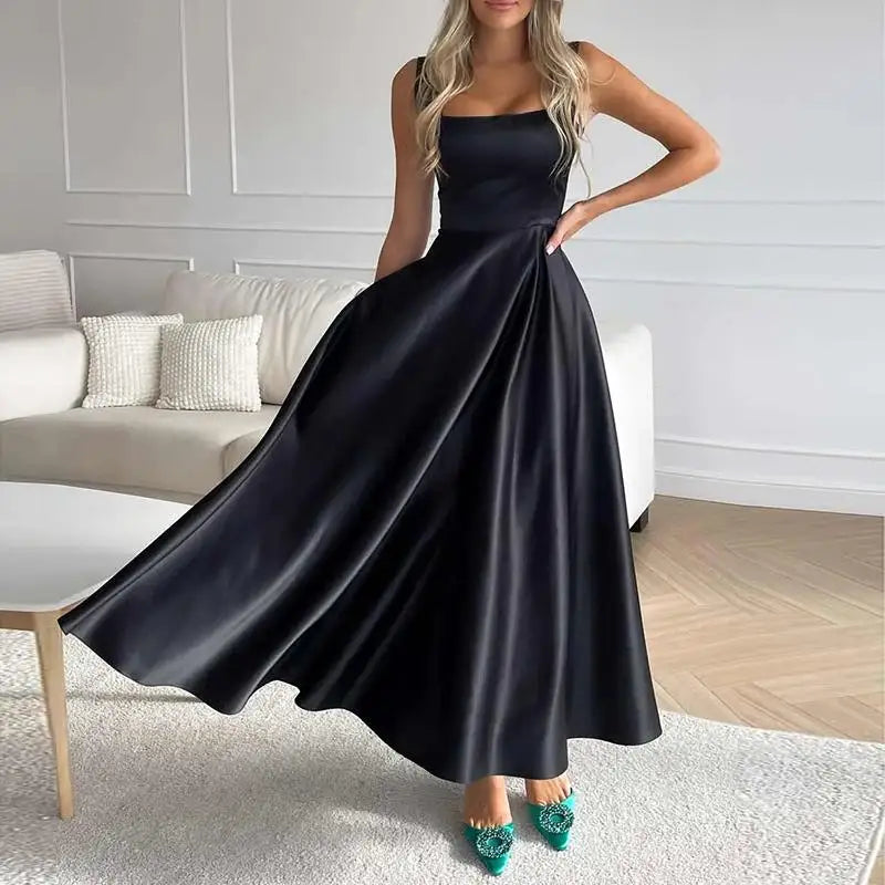 Elegantes schwarzes Abendkleid mit weitem Rock und grünen High Heels im modernen Wohnzimmer