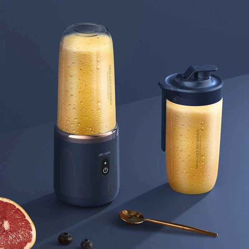 Elektrischer Smoothie-Mixer mit tragbarem Trinkbecher, gefüllt mit frischem Orangensaft, auf dunklem Hintergrund