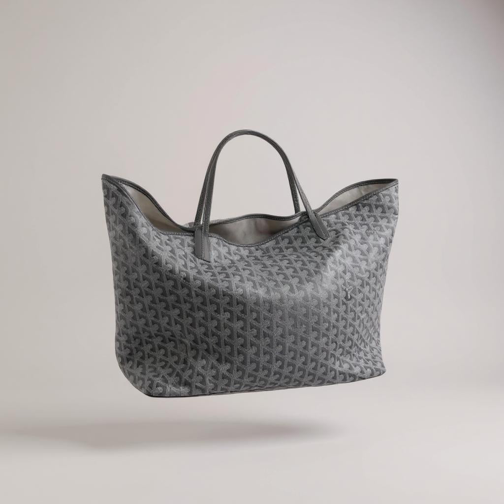 Blaue Tote Bag mit weißen geometrischen Mustern und langen Henkeln, vor hellem Hintergrund schwebend dargestellt.