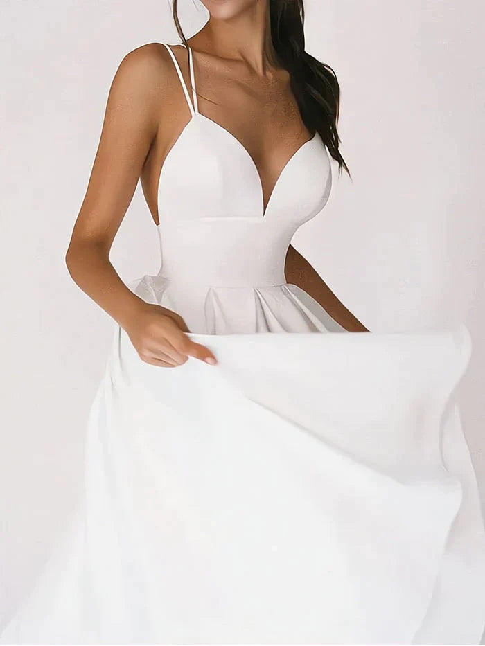 Elegantes weißes Sommerkleid mit offenem Rücken und Spaghettiträgern, kombiniert mit goldenen High Heels
